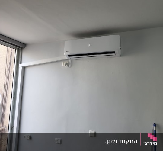 מזגן מותקן על קיר לבן בחדר